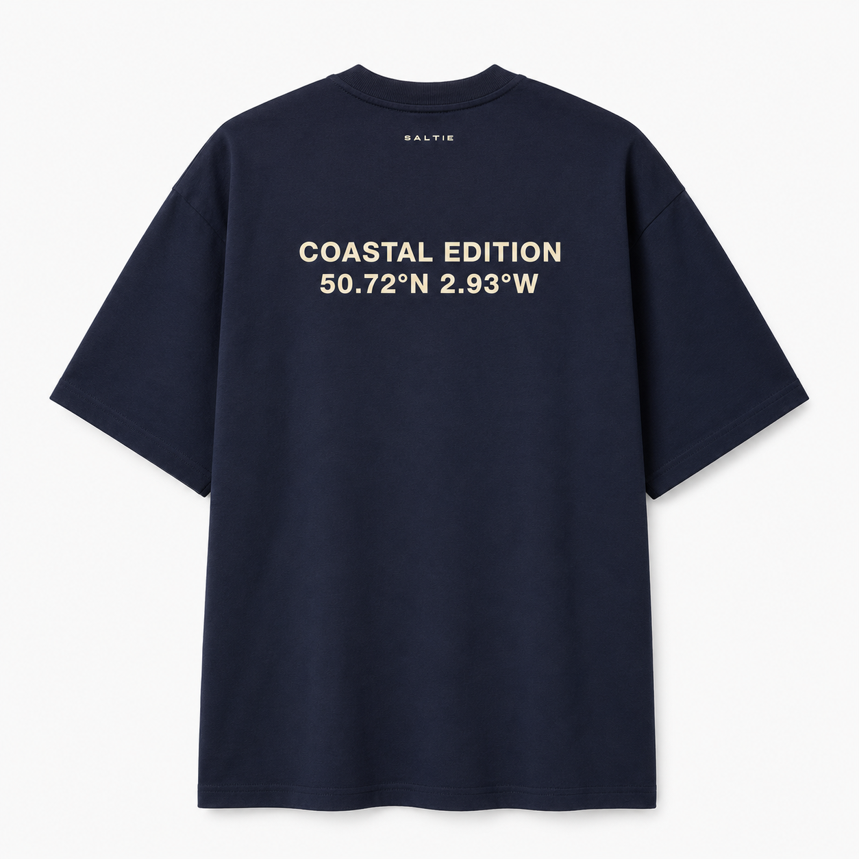 A navy blue shirt against a white background, That says coastal edition on the back of it in a beige colour.
