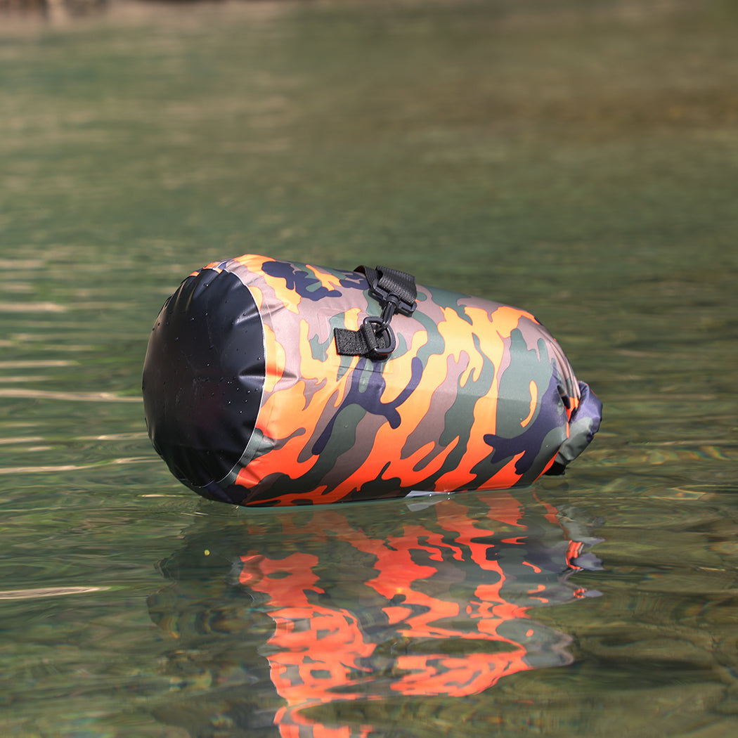 A branded saltie dry bag with a camouflage orange pattern. In the image the bag is floating on the water.