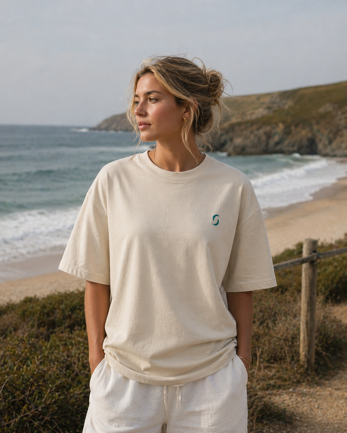 Woman wearing a beige t-shirt with a logo on a beach