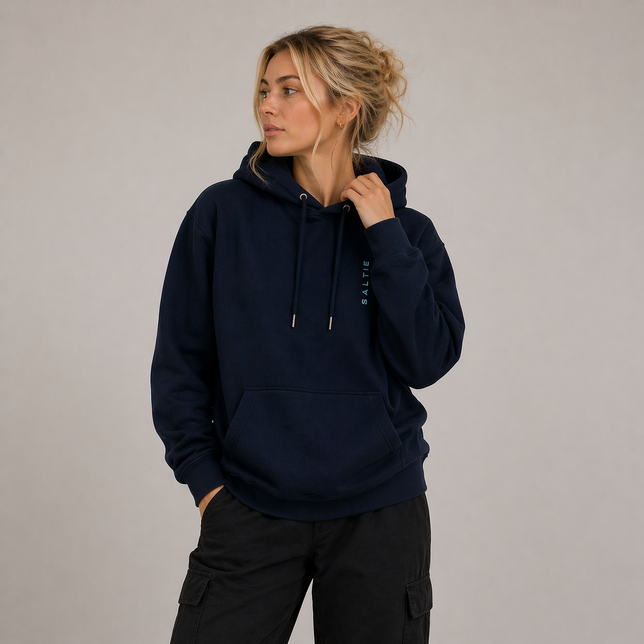 A woman wearing a navy blue hoodie against a white background.