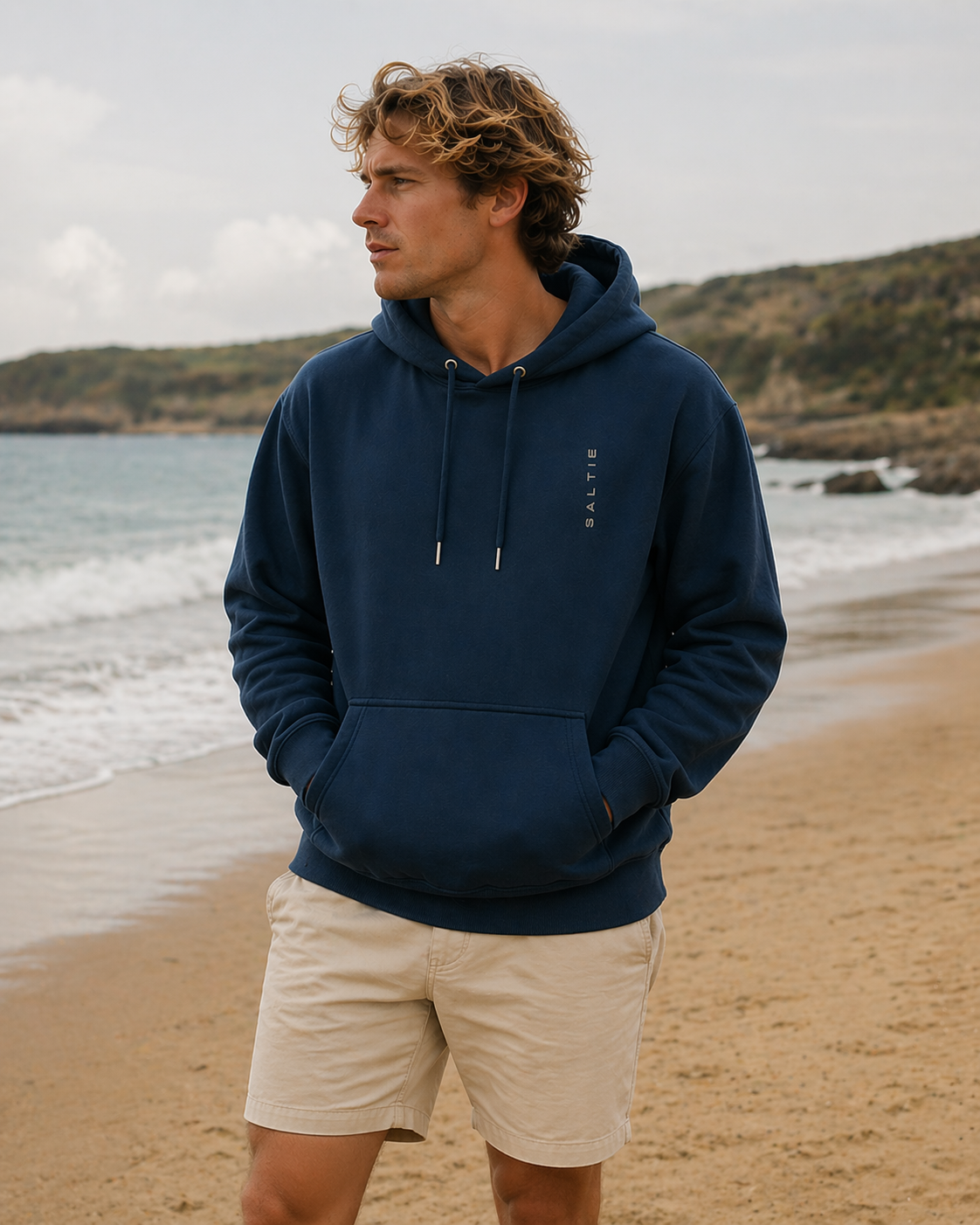 A man wearing a navy blue hoodie with the text