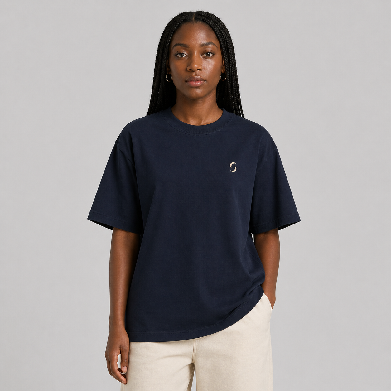Person wearing a navy blue T-shirt with a small