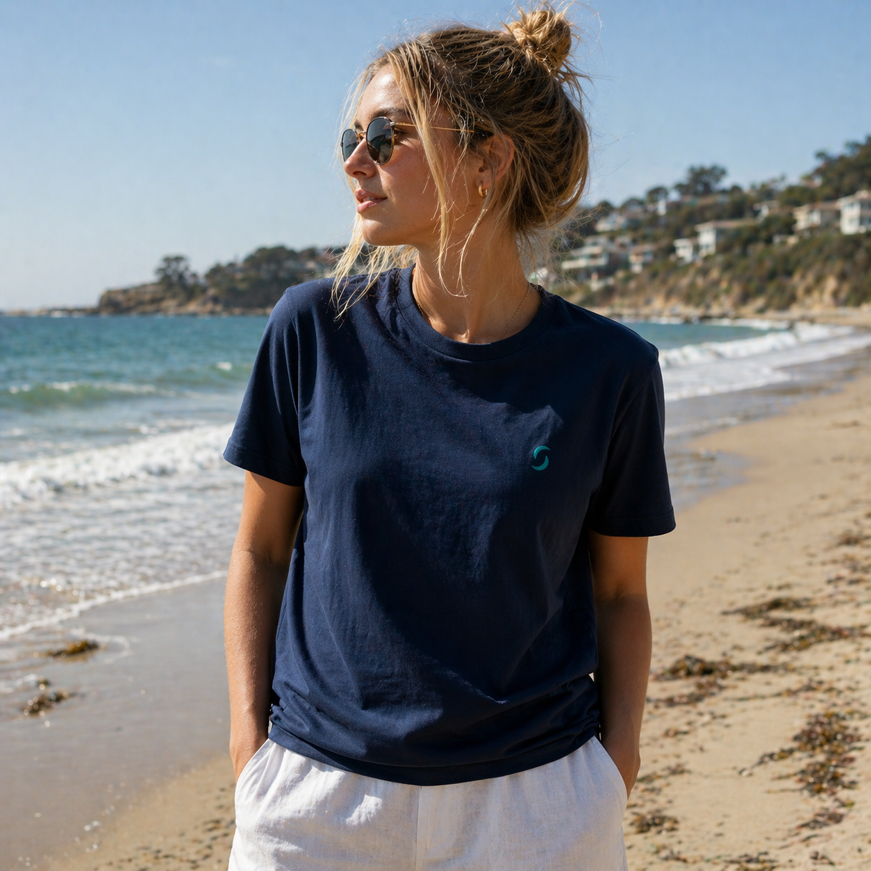 Woman wearing a navy blue t-shirt with a logo on a beach