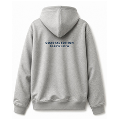 A branded saltie hoodie against a white background. The main colour is grey. The image displays the back of the hoodie with the logo that reads "coastal edition" in a deep navy blue colour.
