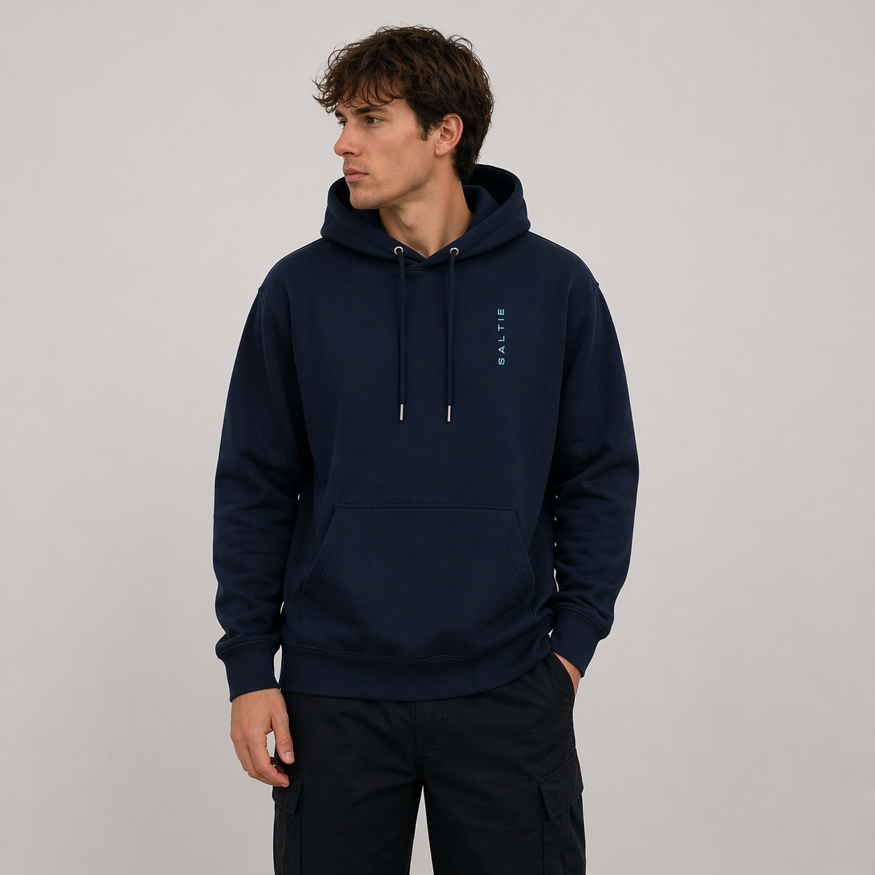 A man wearing a navy blue hoodie against a white background. the logo reads 