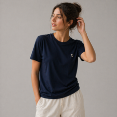 A person in a navy T-shirt posing against a grey background