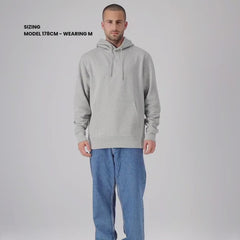 A man wearing a grey hoodie against a white background.