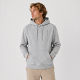 Man wearing a gray hoodie with a small logo on a light gray background